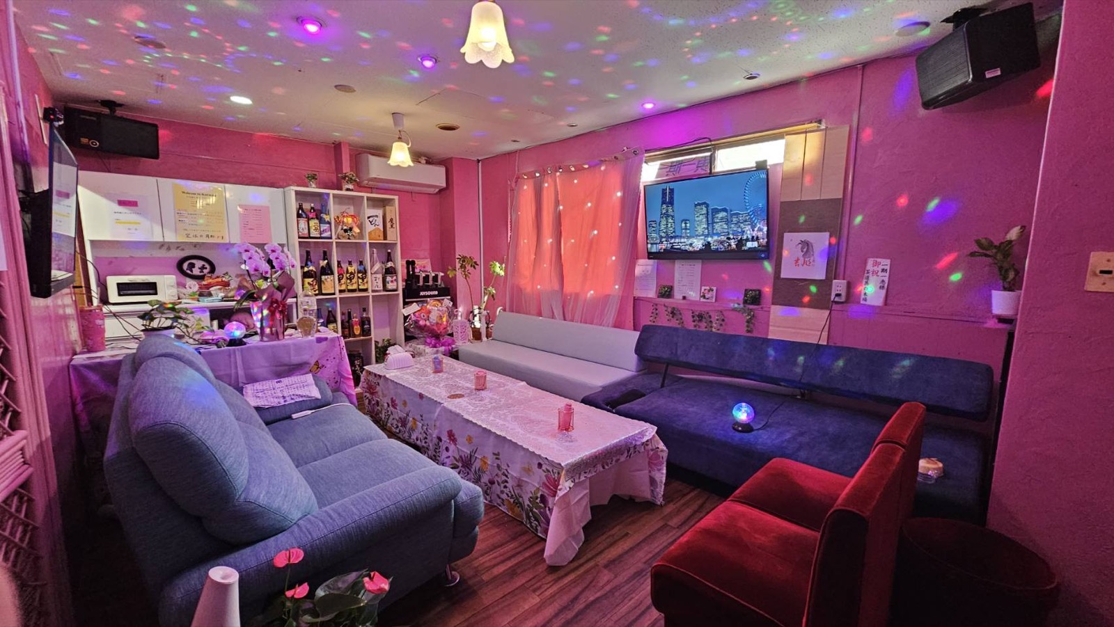 棚にボトルが並び、テーブルを囲むソファ席が見える店内。