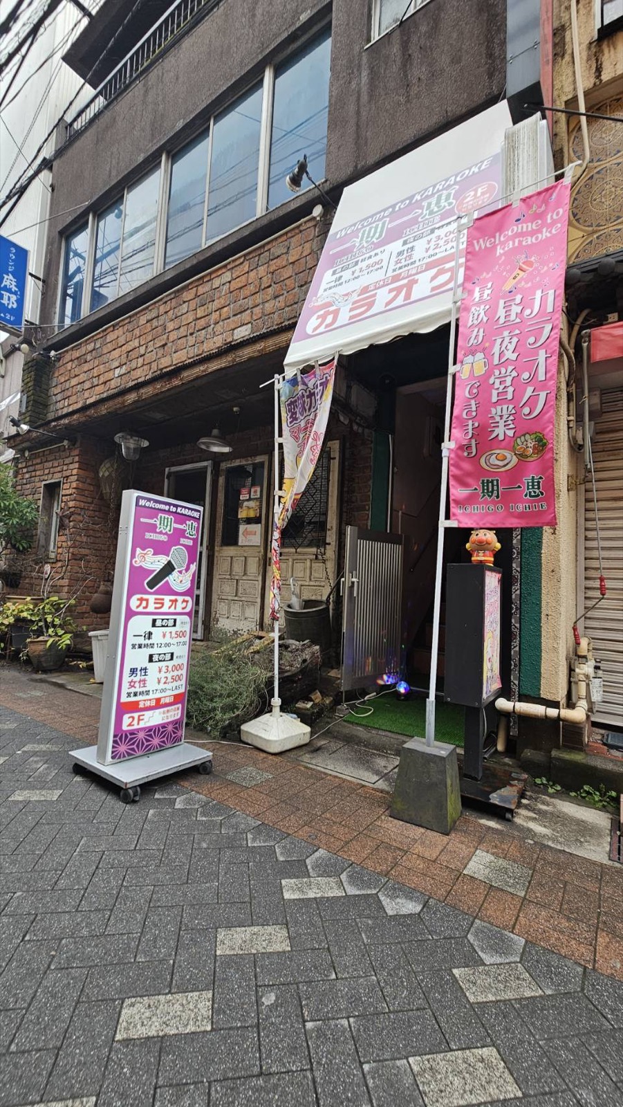 店舗前の様子。のぼり、入口階段、立て看板が見える。